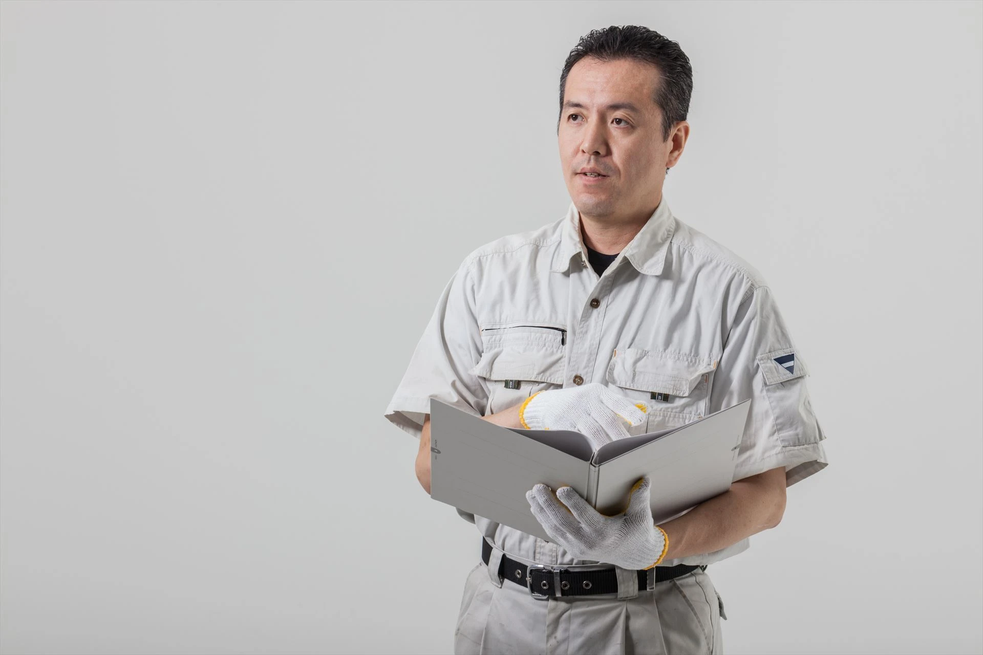 話をする作業服の男性_R